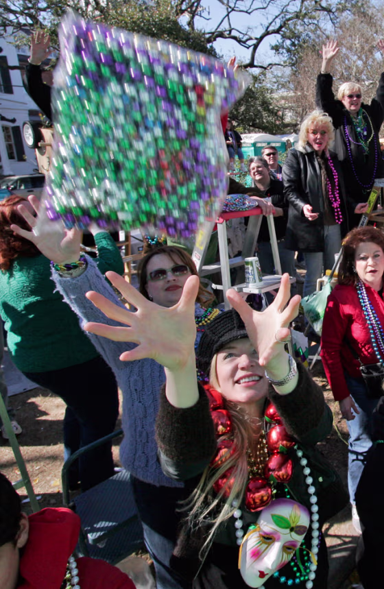 People reach for a&nbsp;bag of beads&nbsp;thrown their way as&nbsp;the Krewe of Thoth rolls during their Mardi Gras parade through the Uptown area of New Orleans Sunday.