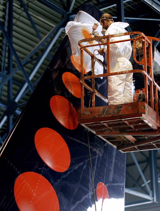 Workers change the 13-ball logo on the tail of a Brussels Airlines Airbus 319 and add a 14th. Superstitious beliefs led to the logo change.