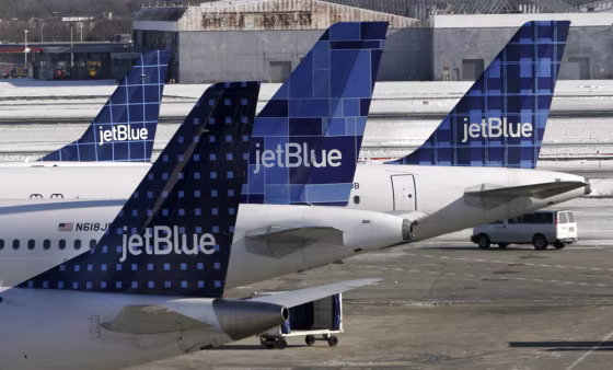 JetBlue planes wait at terminal gates at JFK Airport in New York on Feb. 16. JetBlue travelers continued to experience delays and cancellations as the airline struggled for a third day to recover from an operational meltdown.