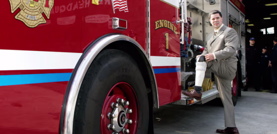 Isaac Feliciano poses next to the Paterson Fire Department's Engine 1 truck at fire headquarters in Paterson, N.J., Wednesday.
