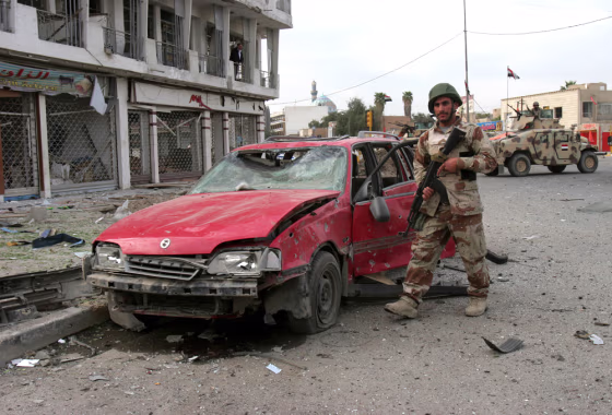 An Iraqi soldier secures an area Thursday after a car bombing in central Baghdad. A suicide bomber apparently targeted a convoy carrying the head of the city council, Sabir al-Issawi, killing eight people.
