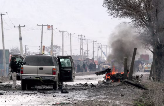 A U.S. security guard stands near the still burning vehicle of a suicide attacker in Kabul, Afghanistan, on Monday. The car bomb exploded next to a U.S. Embassy convoy, pushing an embassy SUV across the road and setting it on fire, officials said.