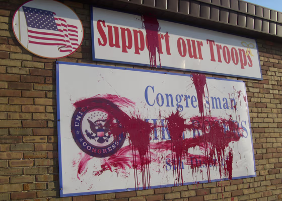 In this photo provided by U.S. Rep. Mike Rogers' office, splattered red paint covers signs at Rogers' Lansing, Mich., office on Tuesday.