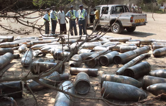 Police officers inspect artillery shells Friday after an explosion Thursday night at a weapons depot in Maputo, Mozambique.