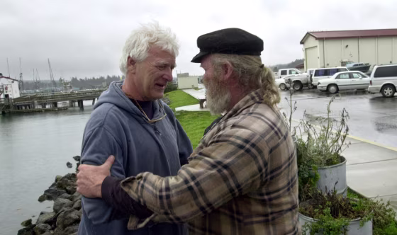Dave Sharp, right, talks with&nbsp;Don Yost, who quit his job as harbormaster rather than impound the boats of salmon fishermen who have fallen months behind in paying their mooring fees, on March 19 in Coos Bay, Ore.