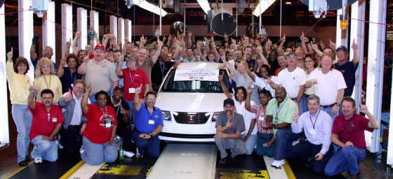 Workers surround the last Saturn Ion sedan that rolled off the line at the Saturn plant in Spring Hill, Tenn.