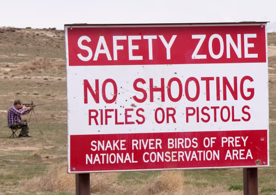 A shooter takes aim Sunday at Paiute ground squirrels at the Snake River Birds of Prey National Conservation Area in Idaho. Thousands of acres of the site have been declared off limits to shooters. The federal Bureau of Land Management is considering forbidding the weapons on another 41,000 acres of the area by this summer: shooters have now taken a bead on National Guard troops, who report slugs bouncing off their tanks on a regular basis.