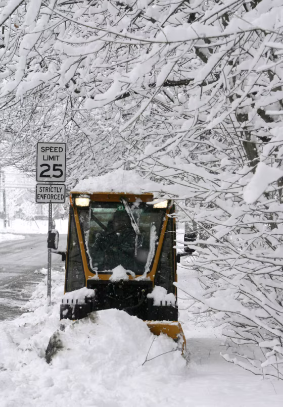 John Fisk of the Montpelier Public Works Department plows a sidewalk Thursday in the Vermont city.&nbsp;A spring snowstorm left up to a foot of new snow in parts of the state.