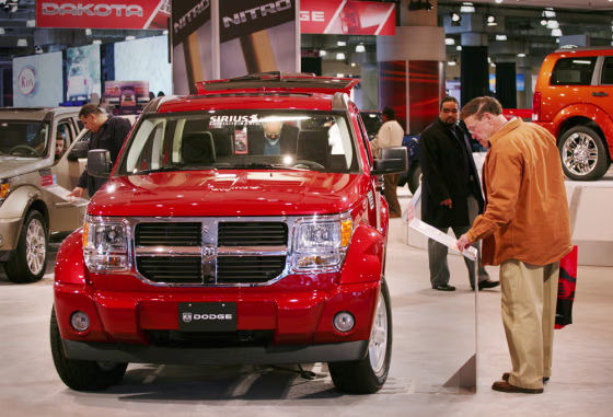 Visitors to the New York International Auto Show look at a Dodge Nitro on Friday. Even the company's top sales executive said the nonstop rumors of an imminent deal have had an impact.