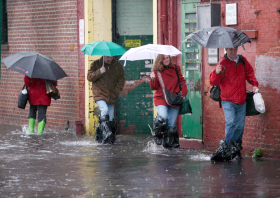 Pedestrians walk through the flooded streets of Hoboken