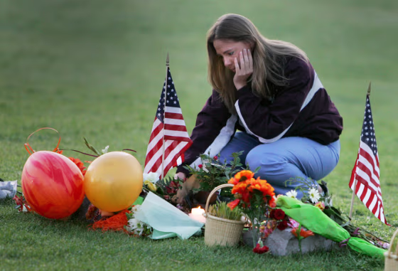 Virginia Tech alumnus Michelle Creamer, 25, of Bracey, Va., visits the makeshift memorial in front of Burruss Hall on the campus of Virginia Tech University in Blacksburg, Va., on Saturday.