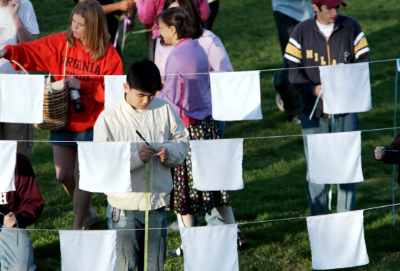 Students gather around white prayer flags outside West Ambler Johnston Hall on the Virginia Tech campus Monday.