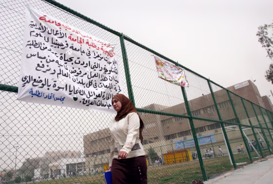 An Iraq student walks past a banner expressing condolences for the shooting victims at Virginia Tech, on the fence of Baghdad Technology University, on Tuesday. Universities and academics have been among the hardest hit by the violence plaguing Iraq, but students still found themselves saddened by last week's massacre at the&nbsp;U.S. university.