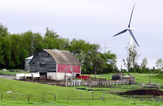 A wind turbine looms behind a farm east of Pipestone, Minn. New worries about the environment, technology advances and tax breaks extensions are empowering European wind energy companies to try their luck in the United States.