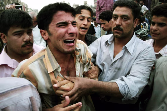 Iraqis try to comfort a weeping man at t