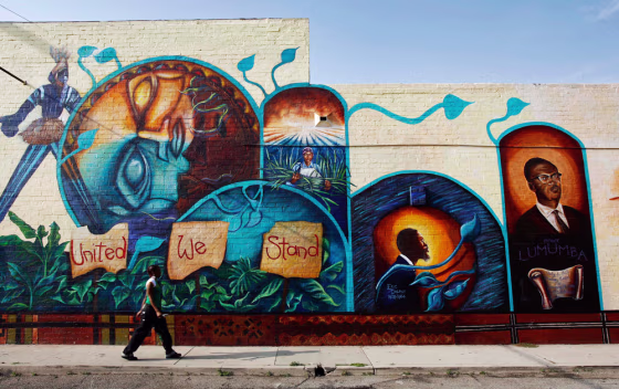 A woman walks in front of a large mural in the Leimert Park Village section of South Central Los Angeles on April 6. The neighborhood is filled wih&nbsp;rows of Afro-centric boutiques, cafes and soul food restaurants.