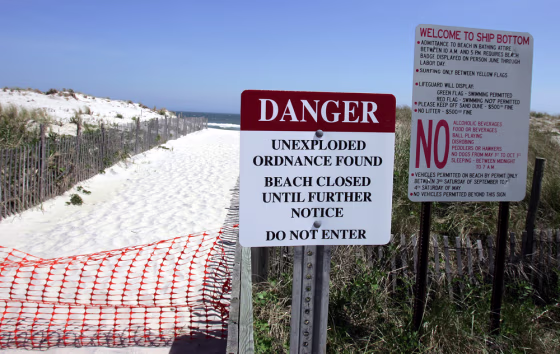 Signs are seen May 15 next to a closed pathway to the beach in Ship Bottom, N.J.