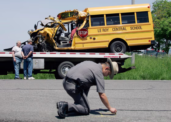 New York State Trooper Jeff Bebak reconstructs an accident scene involving a Le Roy Central School bus and a dump truck in Batavia, N.Y., on Wednesday. The small school bus carrying 14 people collided with a dump truck Wednesday, seriously injuring the driver and two passengers.