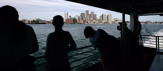 People look at the Boston skyline from a ferry heading to Spectacle Island in Boston.