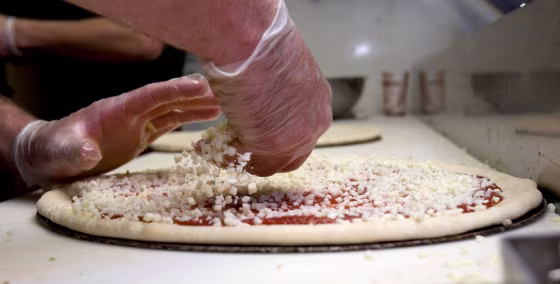 Sharply rising cheese prices has pizza restaurant owners watching the cheese on their pizzas like this one being prepared at Constantly Pizza in Concord, N.H.