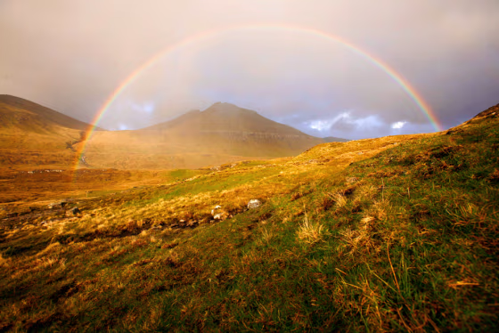 A perfect rainbow arches over the Slaettaratindur mountain on the island of Eysturoy in the Faeroe Islands. The Faeroe Islands are a stunningly beautiful string of islands about halfway between Norway and Iceland in the North Atlantic Ocean.