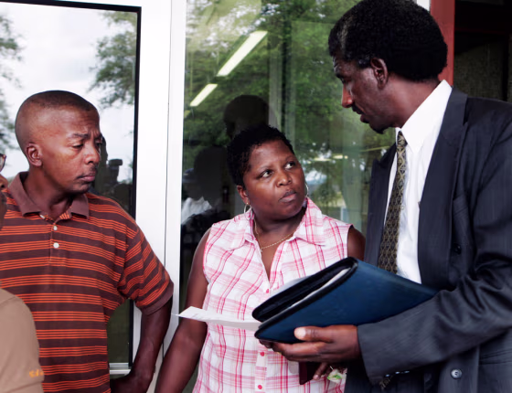 Theodore McCoy and Caseptla Bailey, the parents of two&nbsp;of the teens facing trial, talk with Herbert McCoy, right, before entering the courthouse in Jena, La., on Monday.