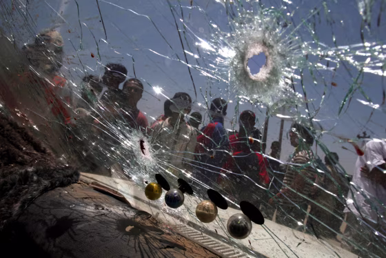 Iraqis gather around a car that was hit by small arms fire in the Shiite enclave of Sadr City in Baghdad on&nbsp;Wednesday.