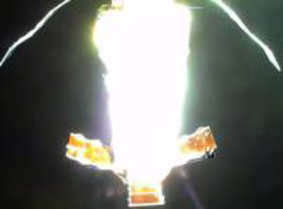 A camera on the end of a forward solar array attached to the Genesis 2 inflatable spacecraft looks back toward the gold-colored aft panels.