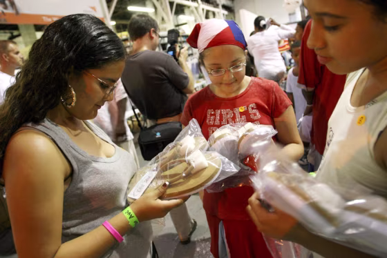 Tanairi Masterreno, 14, left, her sister Maribel Masterreno, 11, center, and Emma Lee Jimenez, 11, take a moment to look at their new summer shoes after receiving them at the Soles4Souls World Vision Summer Shoe Giveaway in the Bronx borough of New York, on&nbsp;July 11, 2007. 