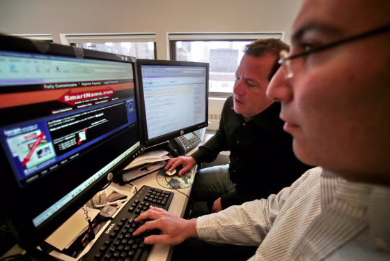 Internet business partners Ari Goldberger, left, and Larry Fischer demonstrate how they search and buy domain names on the Internet, an estimated $2 billion industry.
