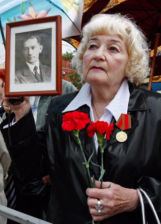 Irina Kalina, 79, holds a portrait of her&nbsp;father, Ignaty, who was&nbsp;accused of being a spy and died in jail.&nbsp;Irina was sent to a labor camp in Kazakhstan for five years.