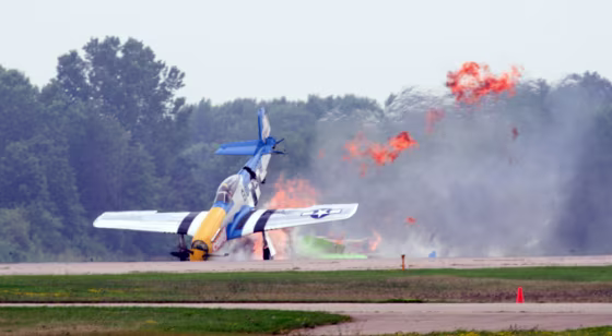 A vintage P-51 Mustang smashes into the ground at the Experimental Aircraft Association's annual AirVenture show in Oshkosh, Wis., on Friday after colliding with another WWII-era fighter. 