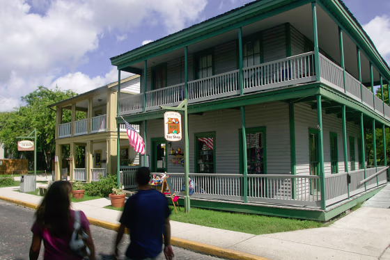 Tourists walk past The Cuna Street Toy Shop, right, and Knock on Wood, two historic buildings on Cuna Street in the historic section of St. Augustine, Fla. The two shops are housed in two of dozens of historic buildings the University of Florida will be maintaining for the City of St. Augustine, Fla. The maintenance and upkeep of the building has become too expensive for the nation's oldest city. 