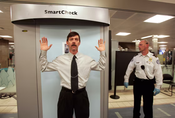 A man passes through an X-ray security scanner as TSA officer Tim Engelby controls the device at Phoenix's Sky Harbor International Airport earlier this year.&nbsp; It’s time to stop thinking of the checkpoints, the uniforms, the magnetometers and the long lines as the last line of defense terrorist hijackers — and more as part psychological deterrent, part safety blanket for nervous airline passengers, travel columnist Christopher Elliott writes.
