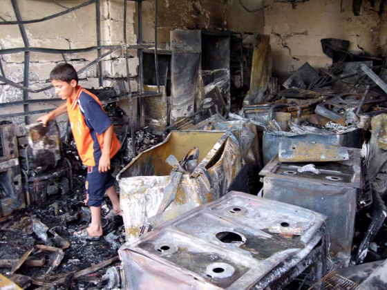 A boy picks through the wreckage of a shop after a suicide car bomber drove into a crowed market in Kirkuk, Iraq, on Friday. 
