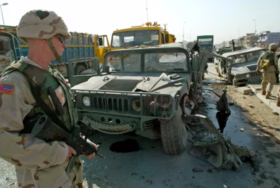 A U.S. soldier stands guard near a Humvee destroyed by an explosive device in Mosul, Iraq.