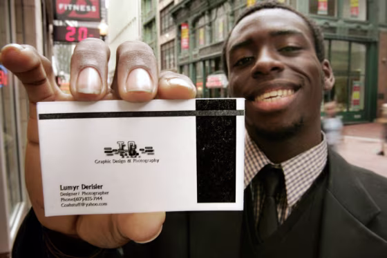 Lumyr Derisier of Milton, Mass., shows off his business card he designed. Experts say business cards technology is expanding the function of the cards rather than hindering it.