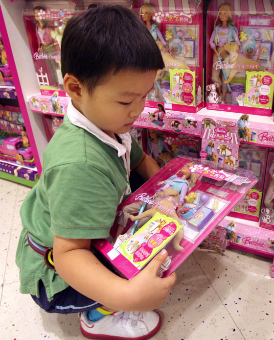 A Chinese boy holding a Mattel "Barbie and Tanner" still for sale in China despite being recalled in the U.S., at a department store in Shanghai last month. Mattel issued an extraordinary apology to China Friday, saying it was to blame for design flaws.