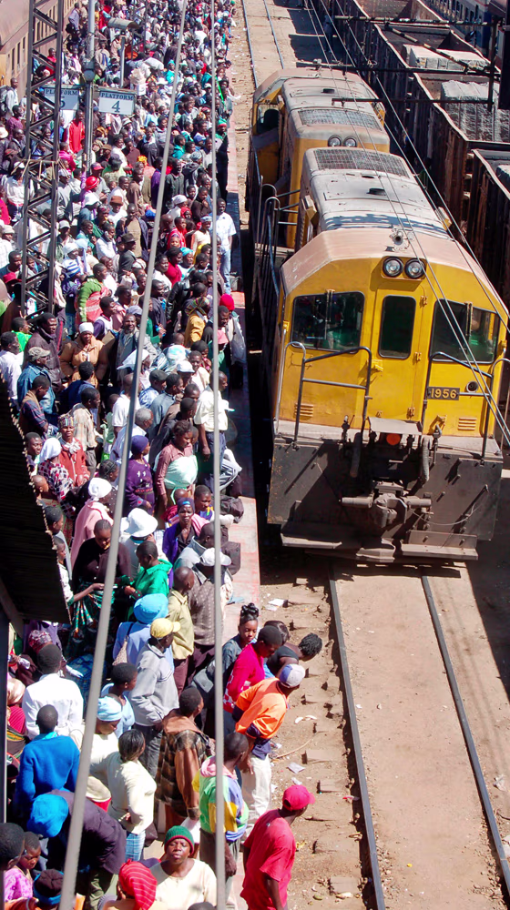 Zimbabweans wait for a domestic train in Harare, Zimbabwe, as the newly-appointed finance mnister massively devalues the local dollar in a bid to attract scarce foreign currency