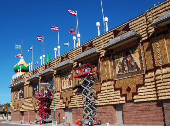 Workers on scissor lifts create murals out of corn on the side of the Corn Palace in Mitchell, S.D.&nbsp;Since the Corn Palace debuted in 1892, its palette has grown to 12 distinct shades of corn.