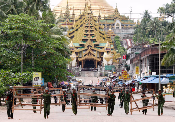 Military officials set up barricades after halting monks from entering the Shwedagon Pagoda in Yangon