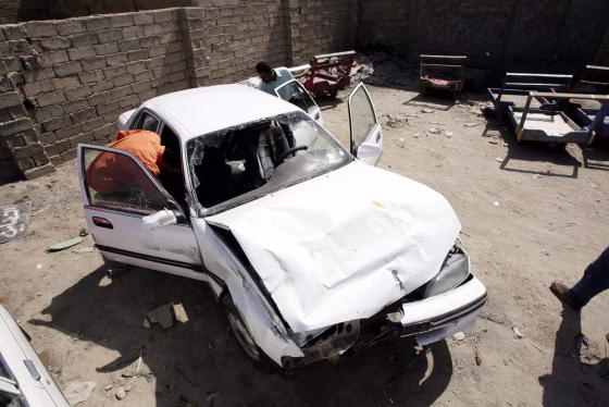 Hussam Hassan inspects his father's car, which was damaged in the shooting incident involving Blackwater USA security guards on Sept. 20, in Mahmoudiya, south of Baghdad.&nbsp;At least 11 Iraqis died in the incident.