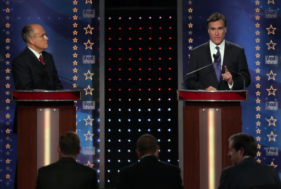 Republican presidential candidate Giuliani listens as Romney makes a point during debate in Orlando