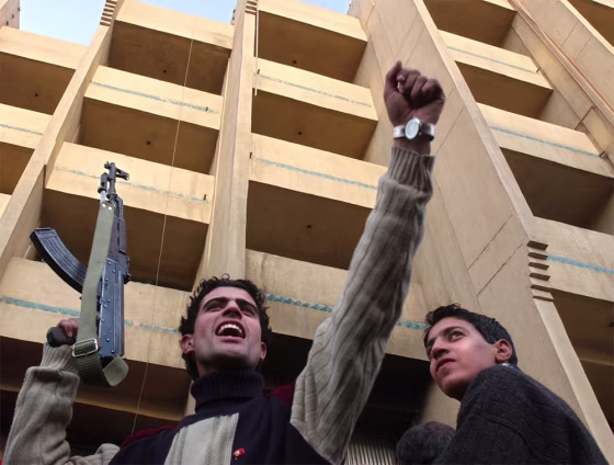 An Iraqi man holds an AK-47 while celebrating news of the capture of former Iraqi leader Saddam Hussein in downtown Baghdad Sunday. Analysts said they expect Iraq's security situation to eventually improve, thus improving the climate for business.