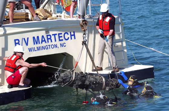 A cannon breaks the surface at Beaufort Inlet as it is recovered off the coast of Atlantic Beach, N.C., on Tuesday. The cannon was raised from what is believed to be the sunken wreck of the Queen Anne's Revenge, flagship of the pirate Blackbeard.