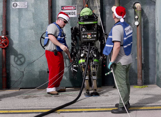  Chris Roberts (L) and Robert Hung prepare their robot from team HKU, the University of Hong Kong, for a challenge during the DARPA Robotics Challenge Trials at the Homestead-Miami Speedway on December 21, 2013 in Homestead, Florida.