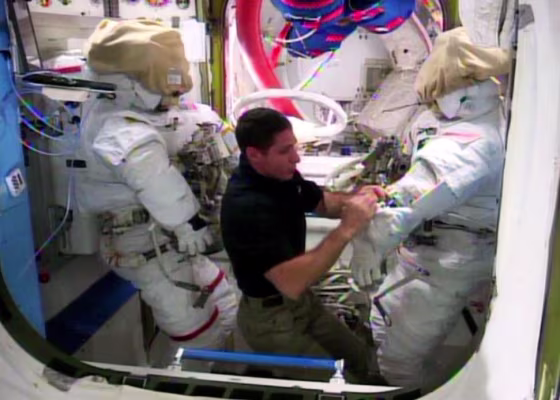 NASA astronaut Mike Hopkins works with spacesuits and spacewalk tools in the International Space Station's Quest air lock in advance of Tuesday's spacewalk to finish repairs on the station's cooling system.
