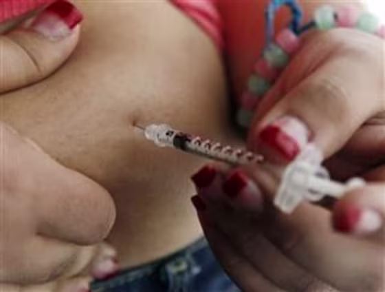 Teenager giving herself insulin injection