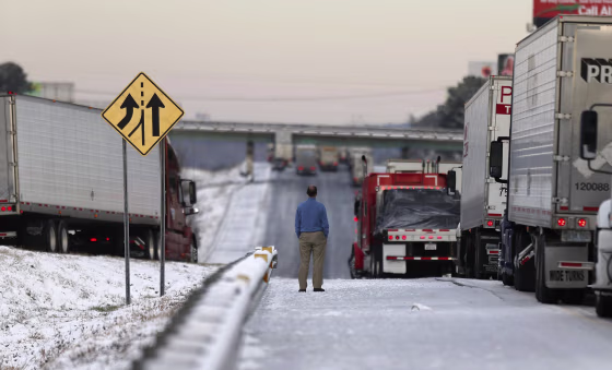 Image: A man stands on the frozen roadway as he waits for traffic to clear along Interstate 75 Wednesday, Jan. 29, 2014, in Macon, Ga.