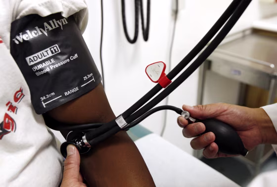 Image: A doctor checks a patient's blood pressure.